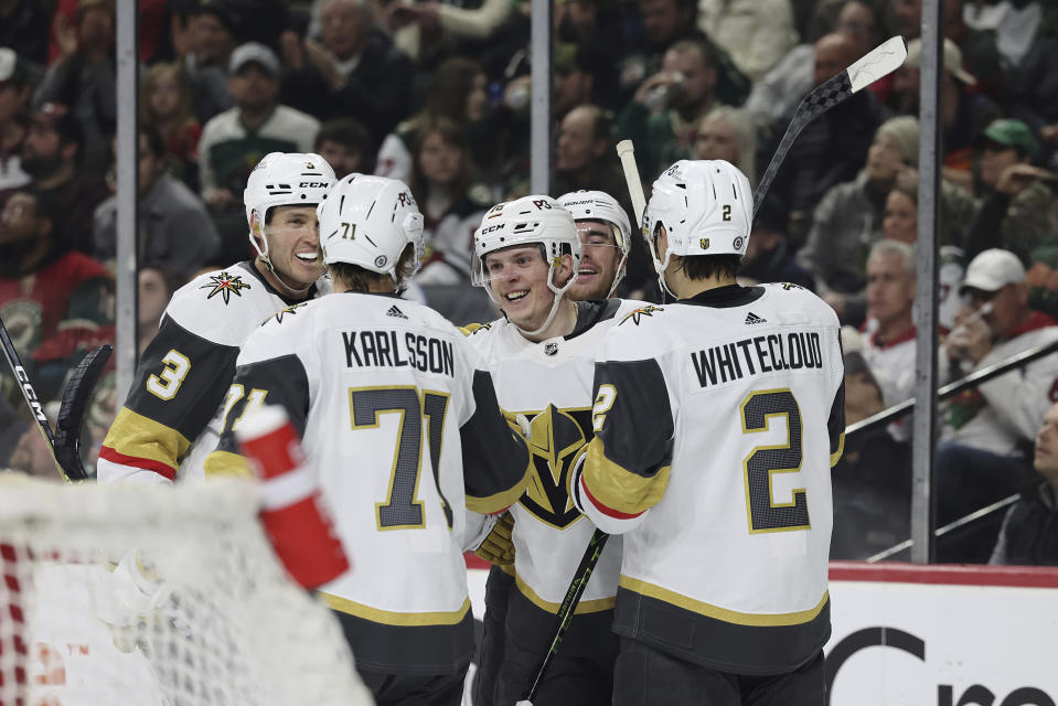 Vegas Golden Knights left wing Pavel Dorofeyev, center, smiles with teammates after scoring against the Minnesota Wild during the second period of an NHL hockey game Monday, April 3, 2023, in St. Paul, Minn. (AP Photo/Stacy Bengs)