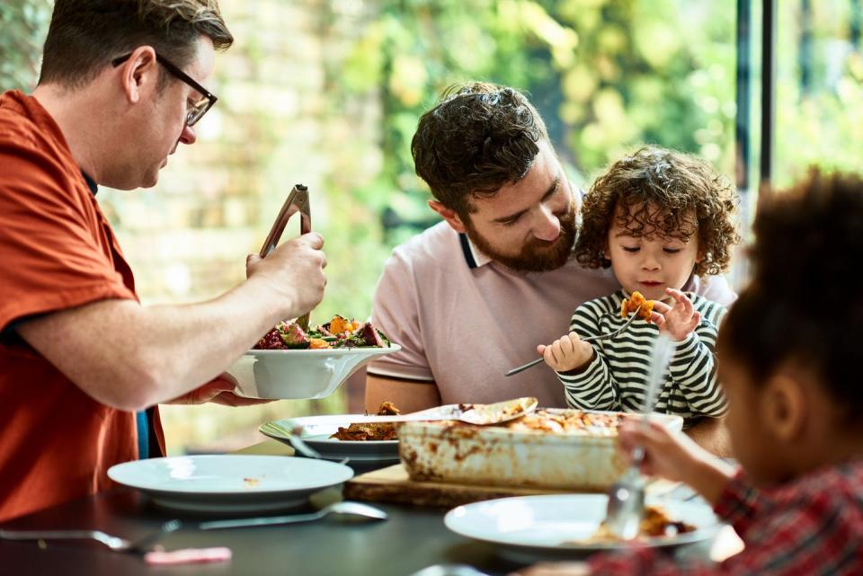 two dads and two kids eating together