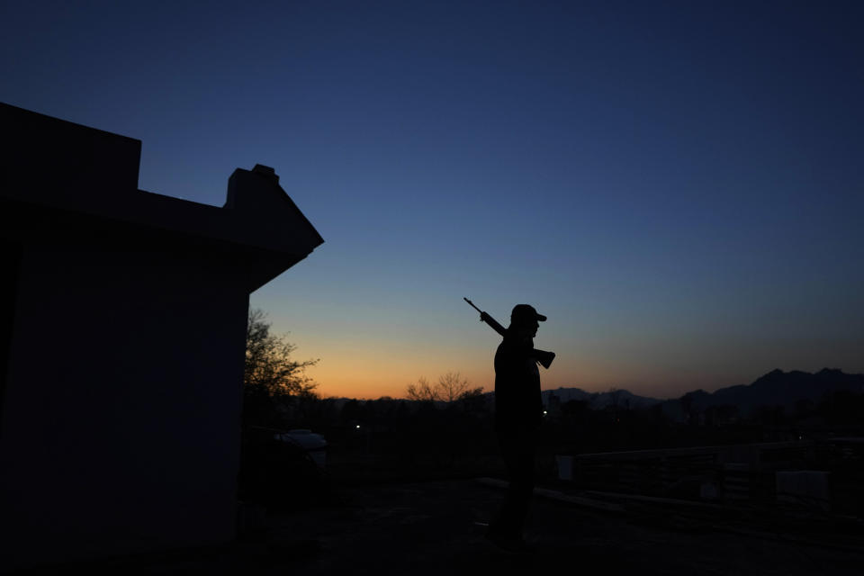 A Village Defense Group member holding a gun walk at rooftop his residence at Dhangri Village, in Rajouri, India, Feb. 7, 2023. Days after seven Hindus were killed in the village in disputed Kashmir, Indian authorities revived a government-sponsored militia and began rearming and training villagers. The militia, officially called the “Village Defense Group,” was initially formed in the 1990s as the first line of defense against anti-India insurgents in remote villages that government forces could not reach quickly. (AP Photo/Channi Anand)