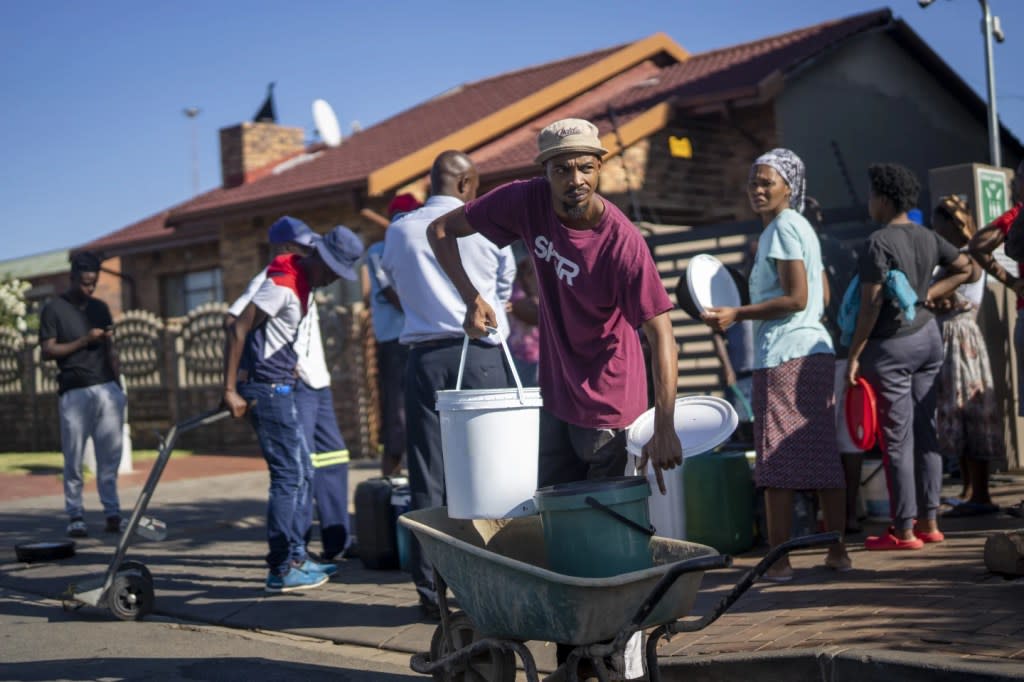 Residents of the township of Soweto, South Africa, queue for water Saturday, March 16, 2024. (AP Photo/Jerome Delay)