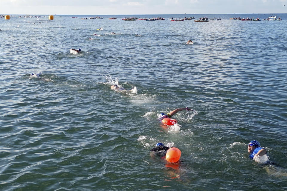 In this photo provided by the Florida Keys News Bureau, swimmers head for their kayaker escorts after beginning the Swim for Alligator Lighthouse open-water challenge, Saturday, Sept. 9, 2023, off Islamorada, Fla., in the Florida Keys. The 8-mile roundtrip race attracted almost 400 swimmers divided into categories including solo and two-, three- and four-person relay teams. The annual event helps raise funds to restore Alligator Reef Lighthouse, one of six aging Florida Keys lighthouses, that are some 150 years old and no longer needed for navigation. The beacon is named for the USS Alligator, a U.S. Navy schooner that ran aground and sank on the reef in 1822. (Andy Newman/Florida Keys News Bureau via AP)