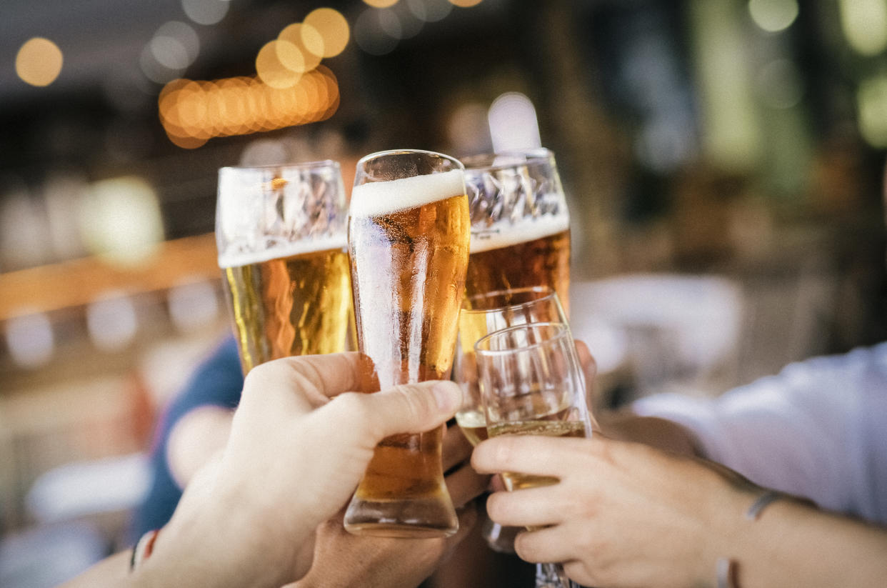 Friends raising celebratory toast during party. Hands of man and woman are holding drinks. They are enjoying at restaurant.