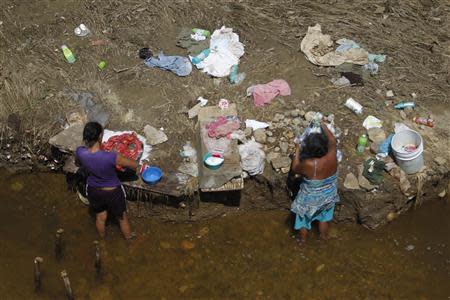 Women wash clothes next to a river in Coyuca de Benitez on the outskirts of Acapulco, October 2, 2013. REUTERS/Edgard Garrido