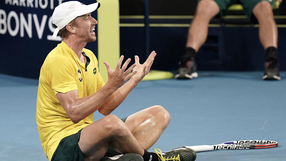 John Millman sitting on the court fuming at the state of the surface after falling over.