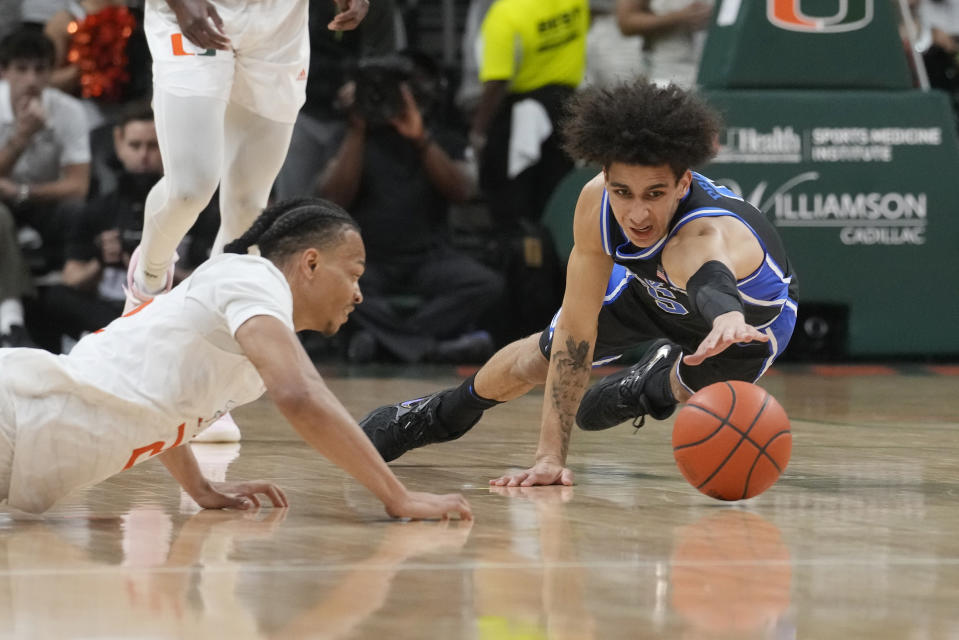 Duke guard Tyrese Proctor (5) and Miami guard Isaiah Wong (2) go after a loose ball during the first half of an NCAA college basketball game, Monday, Feb. 6, 2023, in Coral Gables, Fla. (AP Photo/Marta Lavandier)