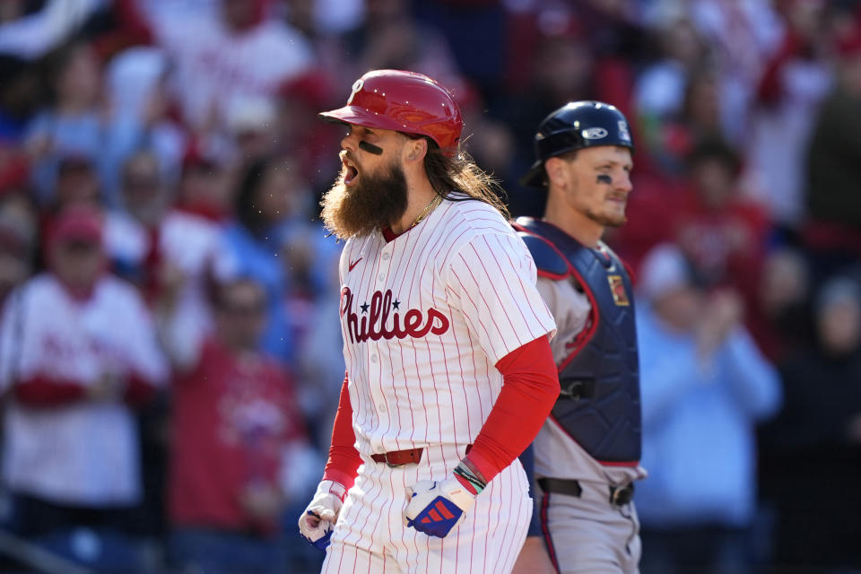 Philadelphia Phillies' Brandon Marsh, left, reacts past Atlanta Braves catcher Sean Murphy after hitting a two-run home run against pitcher Spencer Strider during the fifth inning of an opening-day baseball game, Friday, March 29, 2024, in Philadelphia. (AP Photo/Matt Slocum)