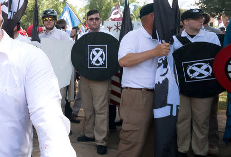 James Alex Fields Jr., (2nd L with shield) is seen attending the "Unite the Right" rally in Emancipation Park before being arrested by police and charged with charged with one count of second degree murder, three counts of malicious wounding and one count of failing to stop at an accident that resulted in a death after police say he drove a car into a crowd of counter-protesters later in the afternoon in Charlottesville, Virginia, U.S., August 12, 2017. REUTERS/Eze Amos