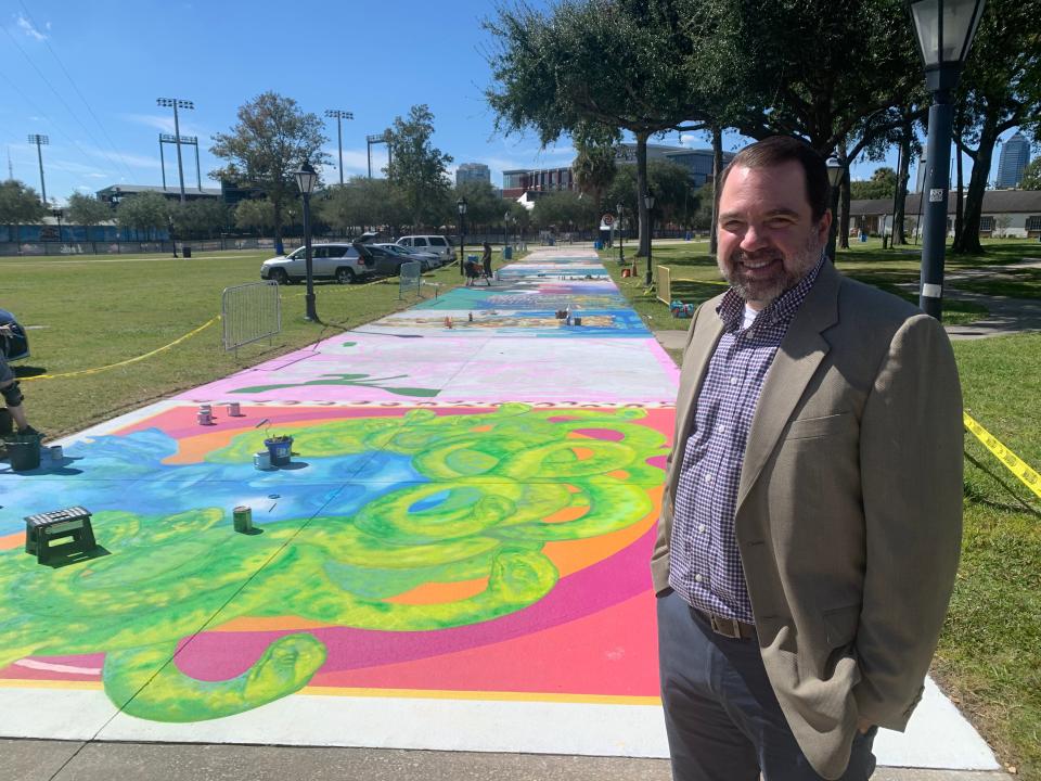 Greater Jacksonville Fair Association President Bill Olson stands on the sidewalk in the Jacksonville Fairgrounds where artists were painting murals in the days leading up to the start of this year's fair.