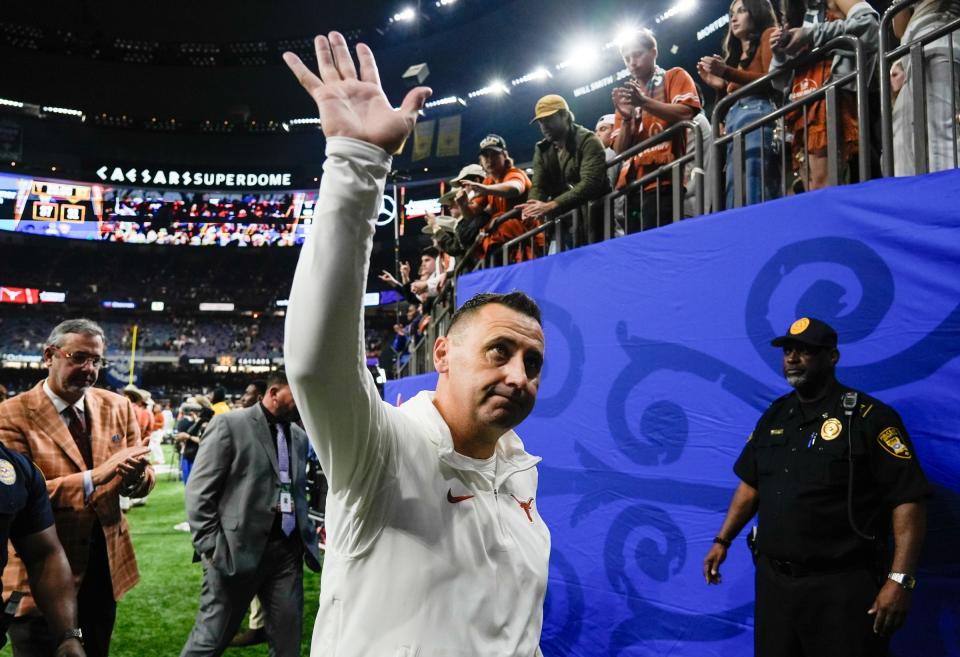 Texas head coach Steve Sarkisian waves to fans as he heads to the locker room after the Longhorns' 37-31 loss to Washington. Texas has improved from 5-7 to 8-5 to 12-2 in his first three seasons in Austin.