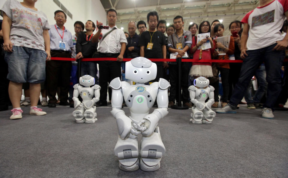 Robots, made by students from Wuhan Institute of Technology University, dance for the visitors at the 13th China International Machinery and Electronic Products Expo in Wuhan, Hubei province, September 23, 2012. REUTERS/Darley Shen (CHINA - Tags: SOCIETY SCIENCE TECHNOLOGY BUSINESS) CHINA OUT. NO COMMERCIAL OR EDITORIAL SALES IN CHINA