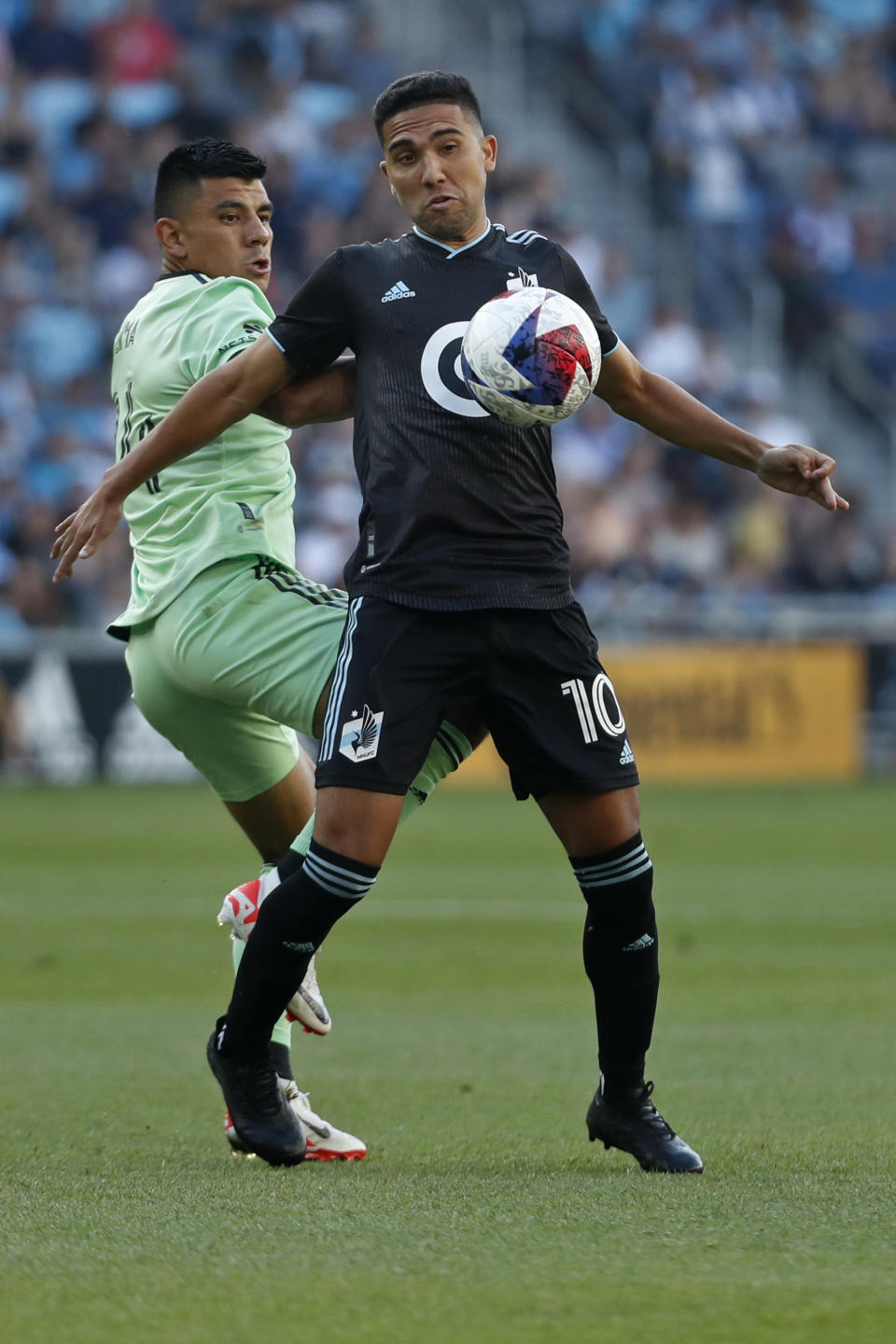 Minnesota United midfielder Emanuel Reynoso (10) traps the ball with his chest away from Austin FC defender Nick Lima, left, in the first half of an MLS soccer game Saturday, July 8, 2023, in St. Paul, Minn. (AP Photo/Bruce Kluckhohn)