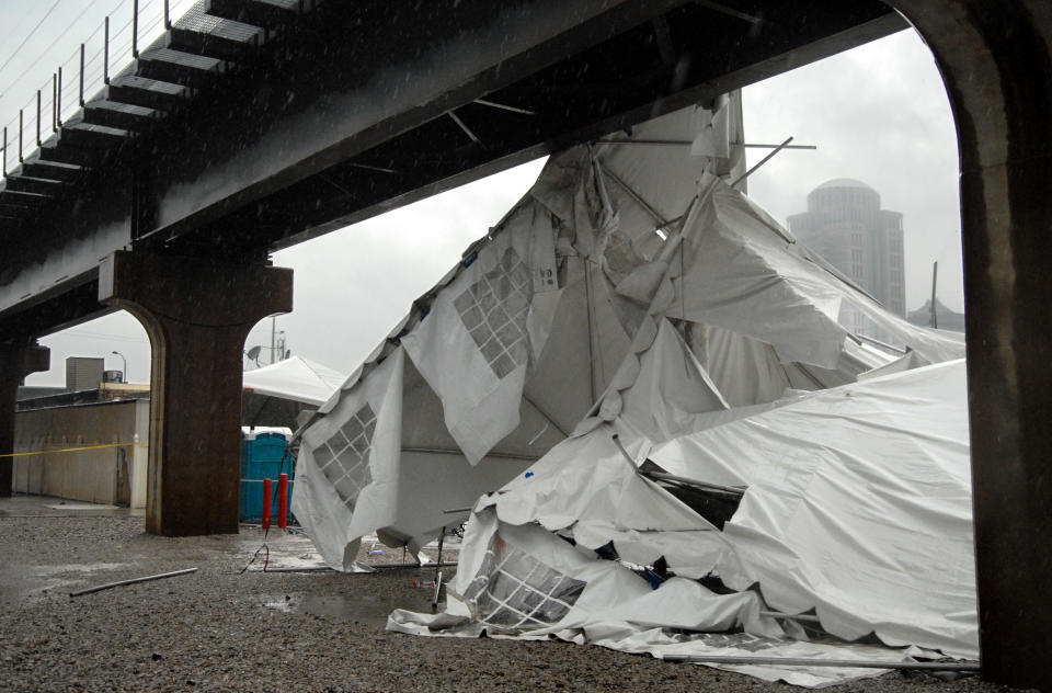 A party tent from Kilroy's Sports Bar in St. Louis rests against a railroad trestle near the bar after storm winds blew through the area following a baseball game between the St. Louis Cardinals and Milwaukee Brewers at nearby Busch Stadium Saturday, April 28, 2012. One person died Saturday and more than a dozen were taken to a hospital with injuries after high winds blew over a beer tent near Busch Stadium in St. Louis. (AP Photo/Sid Hastings)