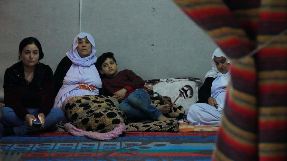 Zena Kalo, 30, speaks to The Associated Press, with her family including her mother-in-law Kauri Kalo, at the tent that her family shares with her sister in law in Kabarto camp in northern Iraq’s Dohuk province on Saturday November 19, 2021. Kalo and her family returned to Iraq from Minsk Friday on a flight organized by the Iraqi government two months after they left for Belarus, driven by dreams of a new life in Europe.(AP Photo/Rashid Yahya)
