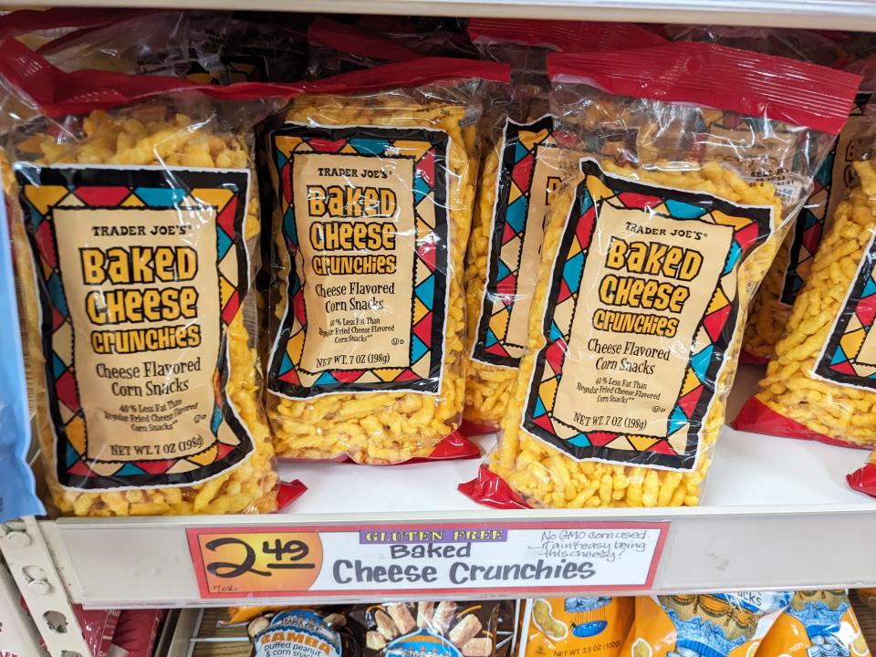 Bags of cheese-flavored corn snacks labelled Baked Cheese Crunchies on shelves at Trader Joe's.