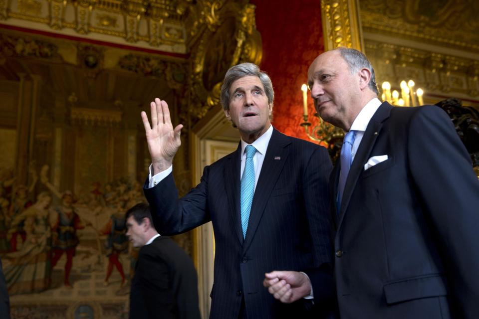 U.S. Secretary of State John Kerry waves to the waiting media as he walks with French Foreign Minister Laurent Fabius for their meeting at the Quai d'Orsay in Paris, Sunday, March 30, 2014. Kerry traveled to Paris for a last minute meeting with Russian Foreign Minister Sergey Lavrov about the situation in Ukraine. (AP Photo/Jacquelyn Martin, Pool)