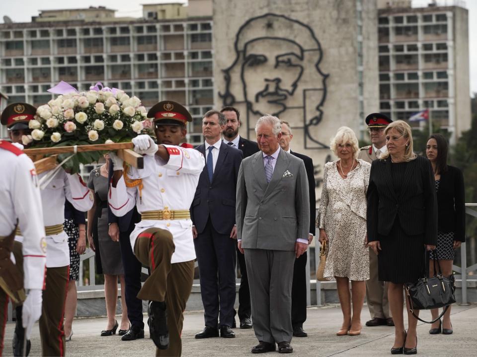 Backdropped by an image of Che Guevara, Britain's Prince Charles, the Prince of Wales, center, and Camilla, Duchess of Cornwall, center right, attend a wreath-laying ceremony at the Jose Marti Monument during their official visit in Havana, Cuba, Sunday, March 24, 2019. (AP Photo/Ramon Espinosa)