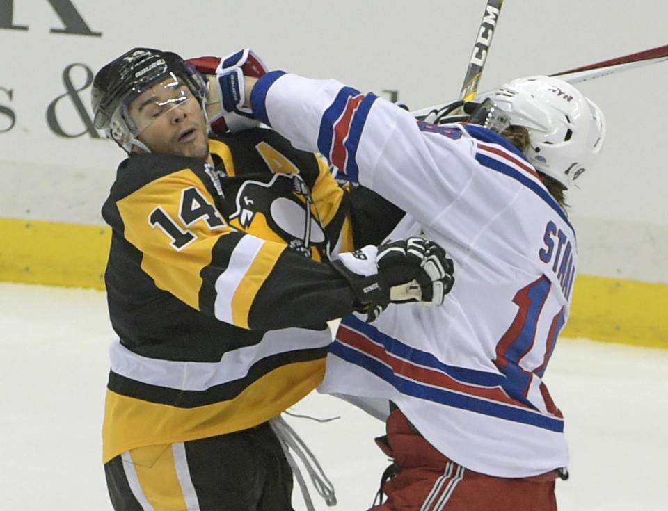 Pittsburgh Penguins left wing Chris Kunitz (14) and New York Rangers defenseman Marc Staal (18) mix it up in front of the net during the first period of an NHL hockey game Tuesday, Dec. 20, 2016, in Pittsburgh. (AP Photo/Fred Vuich)