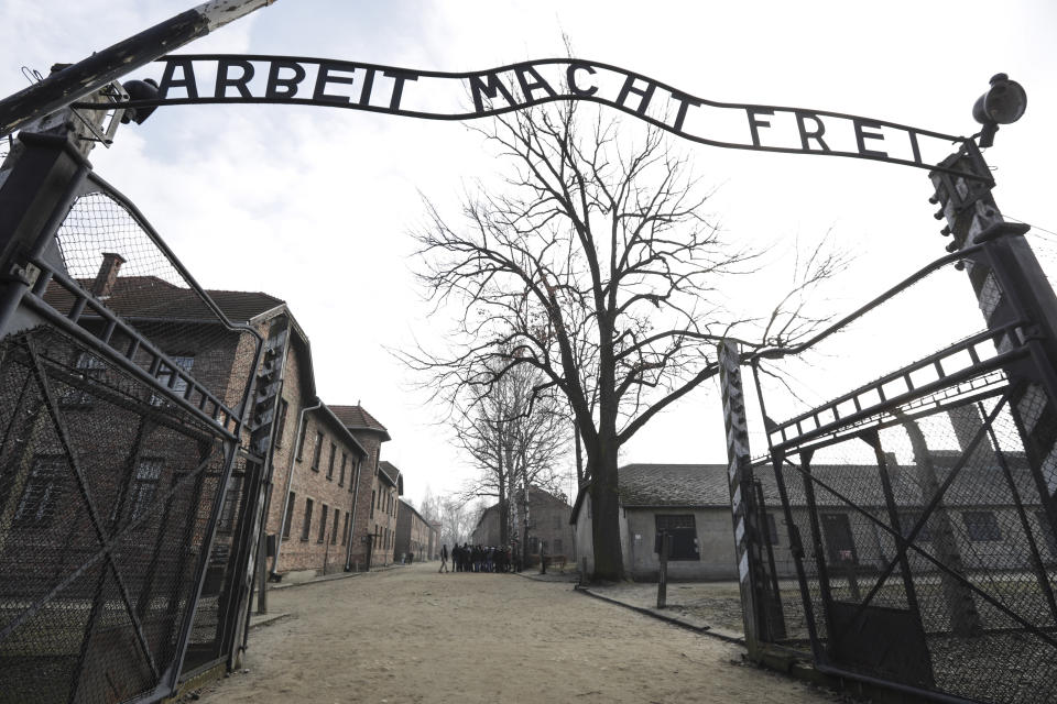 FILE - In this Friday, Feb. 15, 2019 file photo an entrance gate at the Nazi concentration camp Auschwitz-Birkenau is pictured in Oswiecim, Poland. The sign over the gate reads "work makes one free". Germany has agreed to provide more than a half billion euros to aid Holocaust survivors struggling under the burdens of the coronavirus pandemic, the organization that negotiates compensation with the German government said Wednesday. (AP Photo/Michael Sohn,file)