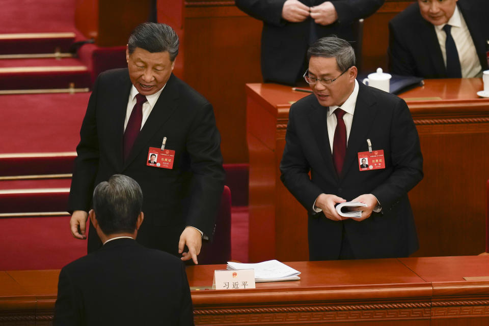 Chinese President Xi Jinping, left, and Chinese Premier Li Qiang react after the opening session of the National People's Congress (NPC) at the Great Hall of the People in Beijing, China, Tuesday, March 5, 2024. (AP Photo/Ng Han Guan)