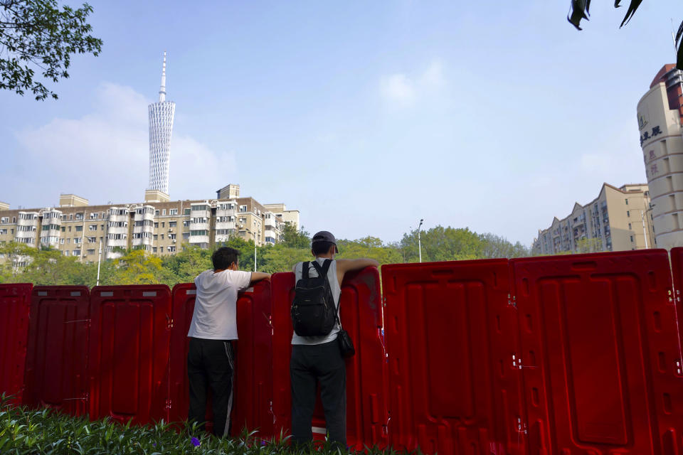 Residents look out from barriers around the recently locked down Haizhu district in Guangzhou in southern China's Guangdong province Friday, Nov. 11, 2022. As the country reported 10,729 new COVID cases on Friday, more than 5 million people were under lockdown in the southern manufacturing hub Guangzhou and the western megacity Chongqing. (AP Photo)