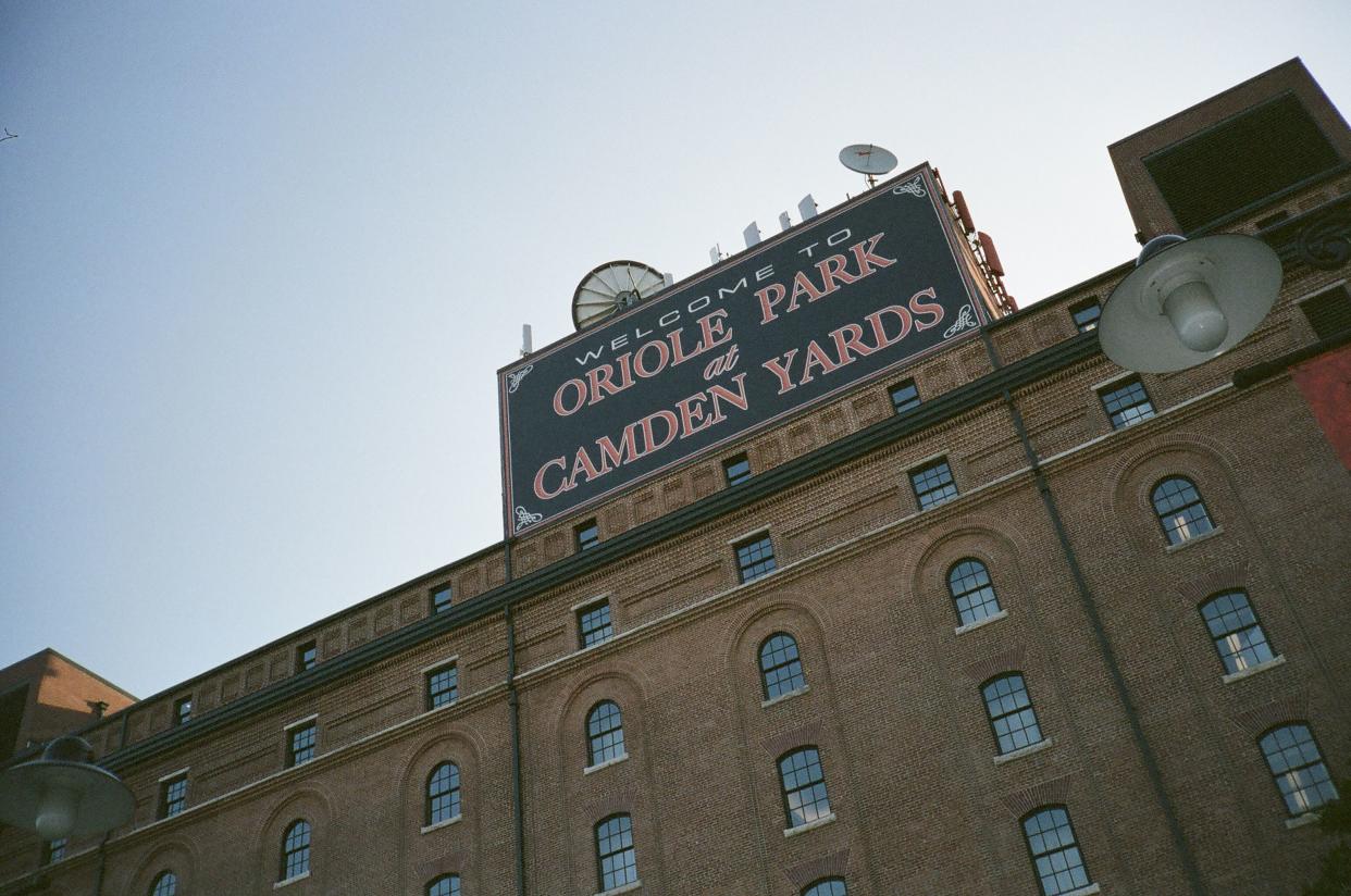 Exterior front sign and upper building of Oriole Park at Camden Yards, Baltimore, home of the Baltimore Orioles with sky in the background