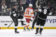 Los Angeles Kings left wing Kevin Fiala, left, celebrates his goal with defenseman Drew Doughty, right, as Calgary Flames center Kevin Rooney skates away during the first period of an NHL hockey game Thursday, April 11, 2024, in Los Angeles. (AP Photo/Mark J. Terrill)