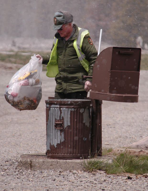 FILE PHOTO: A maintenance worker empties a trash can at Yellowstone National Park