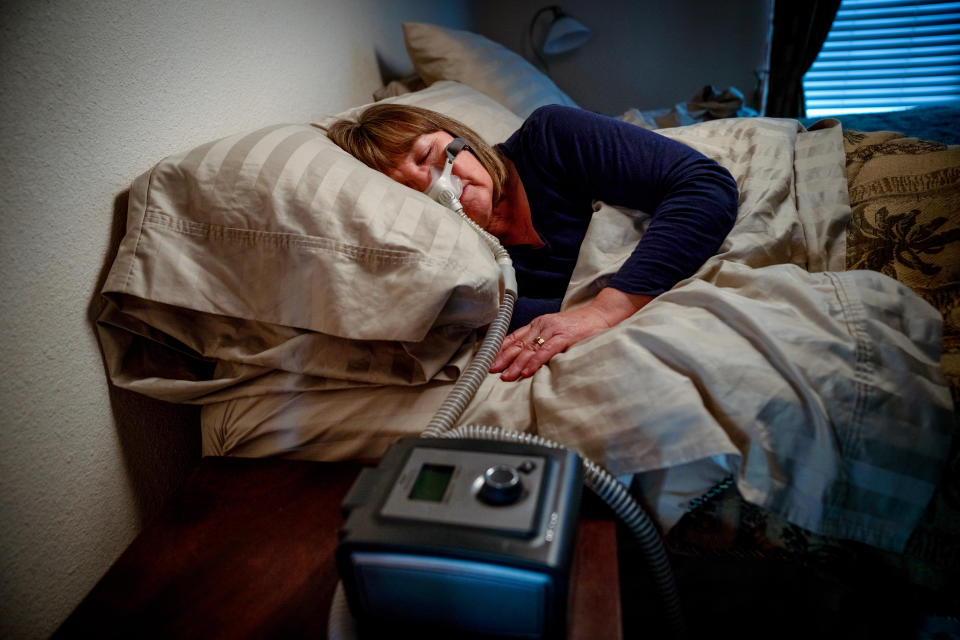 Middle Aged Woman in her Fifties Sleeping Peacefully in Her Bed Using a CPAP Machine to Provide Therapy for Sleep Apnea