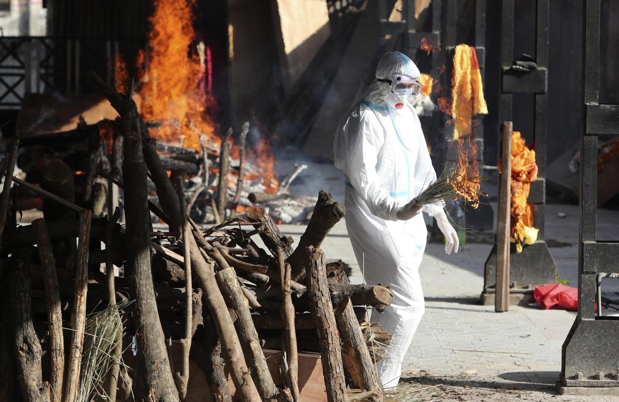 A family member performs the last rites for a COVID-19 victim at a crematorium in Jammu, India, Friday, April 23, 2021. India’s underfunded health system is tattering as the world’s worst coronavirus surge wears out the nation, which set another global record in daily infections for a second straight day with 332,730. India has confirmed 16 million cases so far, second only to the United States in a country of nearly 1.4 billion people. (AP Photo/Channi Anand)