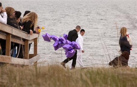Students arrive at the beach for a vigil in honor of slain student Maren Sanchez wearing their prom clothes carrying balloons in Milford, Connecticut April 25, 2014. REUTERS/Michelle McLoughlin