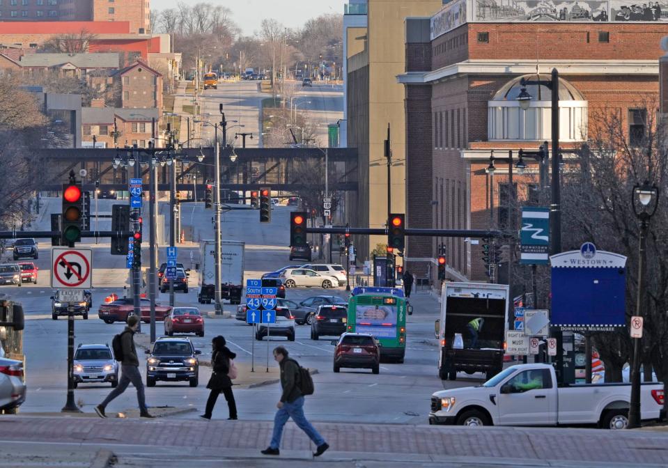 Traffic moves along North Sixth Street looking north as pedestrians cross at West Wisconsin Avenue Avenue in the downtown area in Milwaukee on Wednesday, March 13, 2024. President Joe Biden is expected to highlight a $36.6 million allocation for a project to convert a 2.6-mile section of Sixth Street to a "complete street" during his visit to Milwaukee on Wednesday.