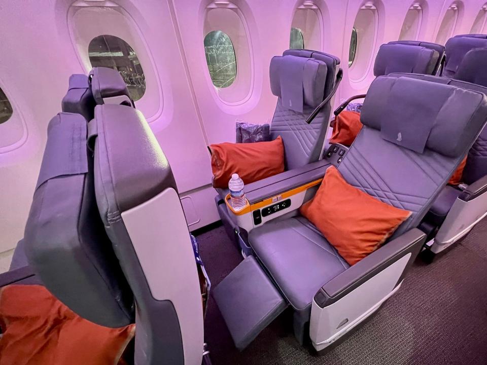 Singapore Airlines premium economy seat fully reclined with legrest out.