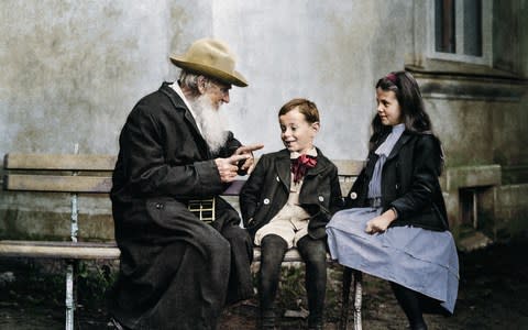 Leo Tolstoy telling his grandchildren a story - Credit: Getty