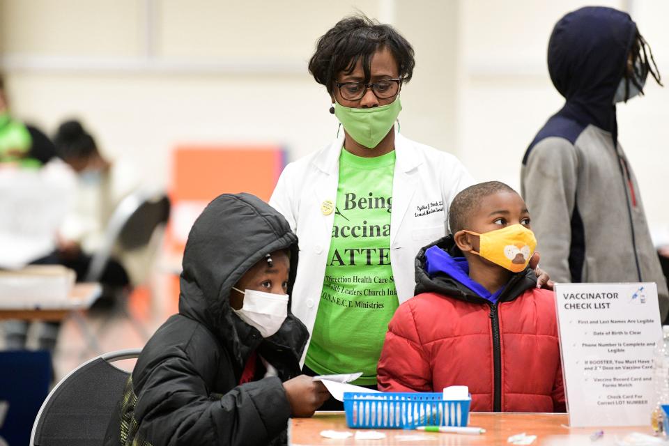 Cynthia Finch guides children to their vaccination station during a COVID-19 vaccine clinic at the Jacob Building at Chilhowee Park in Knoxville, Tenn. on Friday, Jan. 7, 2022. The clinic offered vaccines for children and adults alike as well as activities and information booths from community organizations. The clinic continues Saturday 10am-3pm.