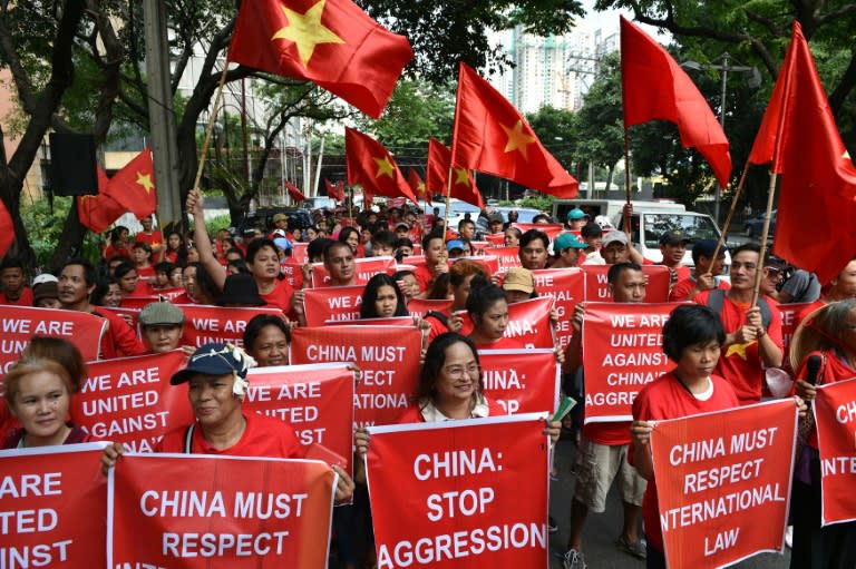 Filipino and Vietnamese protesters display anti-China placards during a call on China to respect their rights in the disputed South China Sea, in front of the Chinese consular office in Manila on August 6, 2016