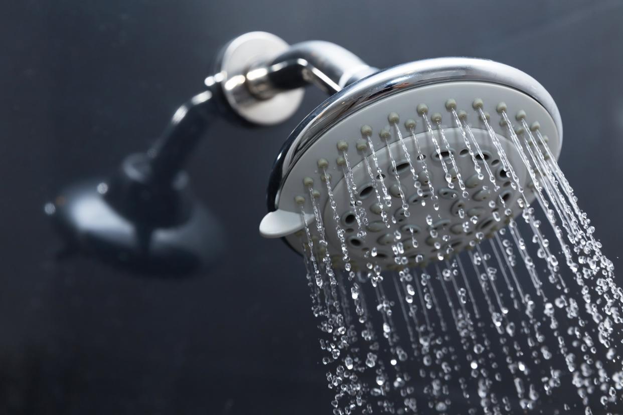 shower head in bathroom with water drops flowing