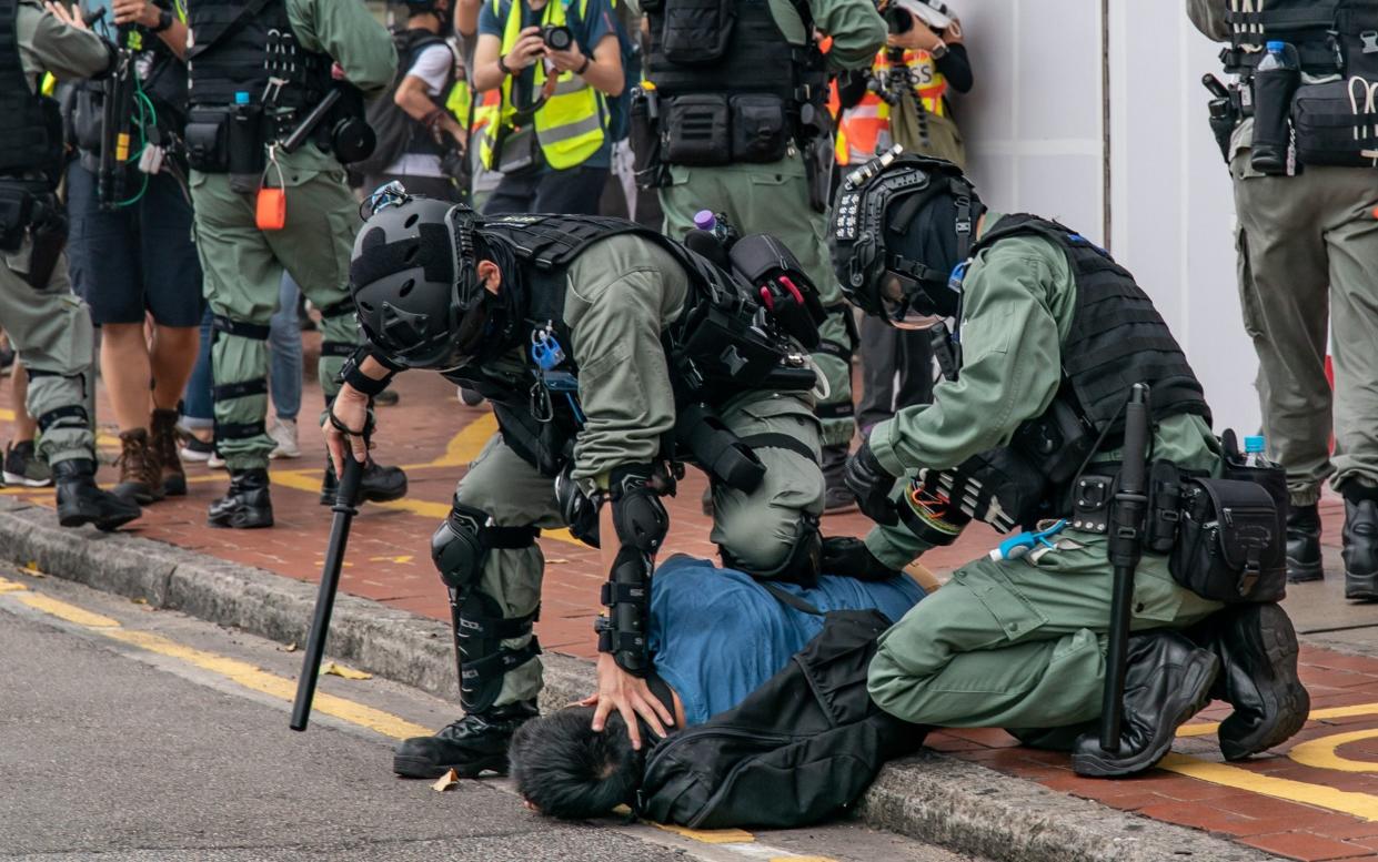 A pro-democracy supporter is detained by riot police during an anti-government rally in Hong Kong - Getty