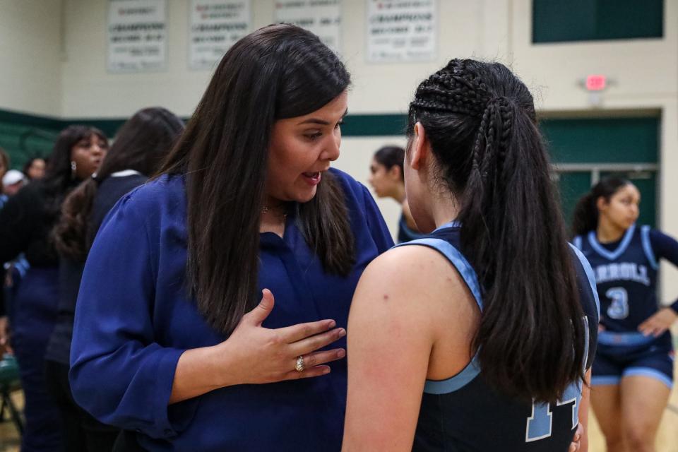 arroll head girls basketball coach Lauren Bell speaks to junior Genesis Barnhart during the District 29-5A South Zone third-place playoff game on Feb. 2, 2023, at King High School, in Corpus Christi, Texas.