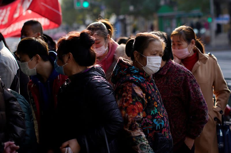 Personas con máscaras en el centro de Shanghái