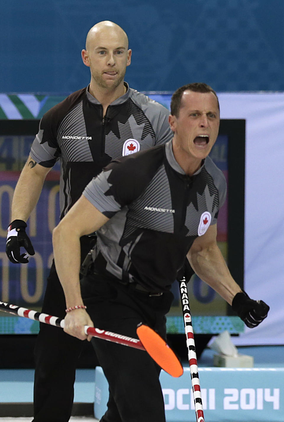 Canada's E.J. Harnden, right, and Ryan Fry, left, celebrate after skip Brad Jacobs delivered the rock to bring their team to a 4-point lead during the men's curling semifinal game against China at the 2014 Winter Olympics, Wednesday, Feb. 19, 2014, in Sochi, Russia. (AP Photo/Wong Maye-E)