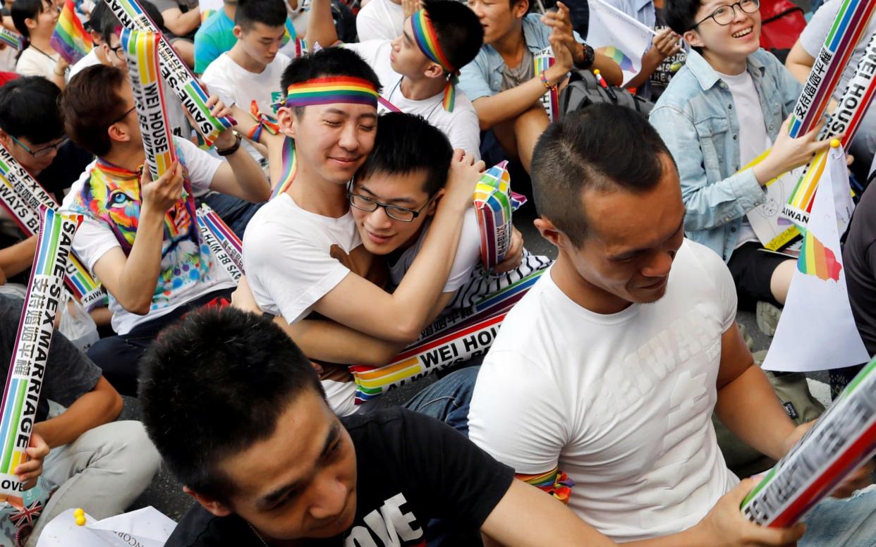 Supporters hug each other in celebration during a rally after Taiwan's constitutional court ruled that same-sex couples have the right to legally marry - REUTERS