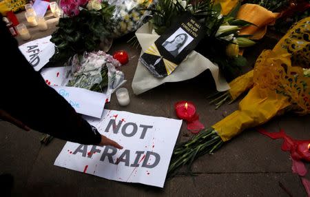 People place posters, candles and flowers at an impromptu memorial during a protest by journalists following the assassination of investigative journalist Daphne Caruana Galizia in a car bomb attack three days ago, in Valletta, Malta, October 19, 2017. REUTERS/Darrin Zammit Lupi