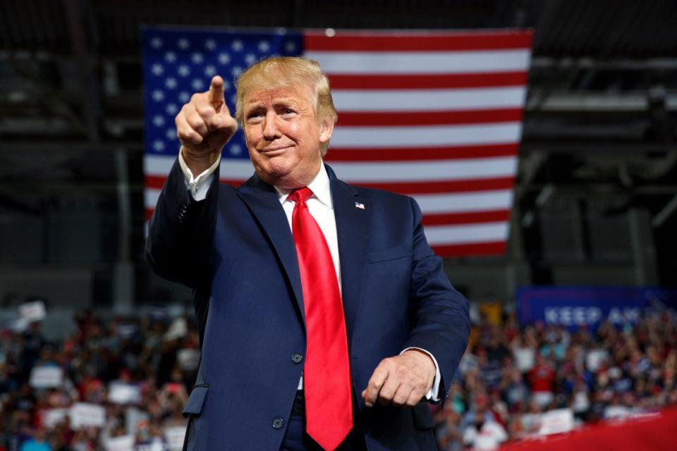 President Donald Trump gestures to the crowd as he arrives to speak at a campaign rally.