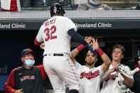 Cleveland Indians' Franmil Reyes (32) is congratulated by teammates after hitting a solo home run during the sixth inning in a baseball game against the Detroit Tigers, Friday, April 9, 2021, in Cleveland. The Indians won 4-1. (AP Photo/Tony Dejak)