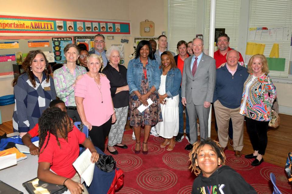Stacey McClary of the Wynnton Arts Academy poses with Muscogee Educational Excellence Foundation board members and Muscogee County School District staff members after she was surprised in her classroom March 14, 2024, with the announcement that she is among the three finalists for MCSD’s Teacher of the Year award.