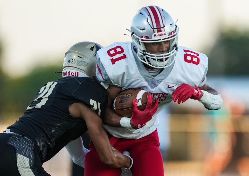 Fishers Tigers wide receiver JonAnthony Hall (81) is tackled by Noblesville Millers cornerback Cole Richardson (21) on Friday, Sept. 1, 2023, during the game at Noblesville High School in Noblesville. The Fishers Tigers defeated the Noblesville Millers, 48-22.