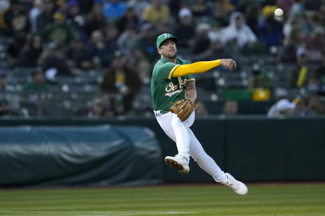 Oakland Athletics third baseman Kevin Smith throws to first base on an RBI-single by Texas Rangers' Jonah Heim during the fifth inning of a baseball game in Oakland, Calif., Friday, May 12, 2023. (AP Photo/Godofredo A. Vásquez)