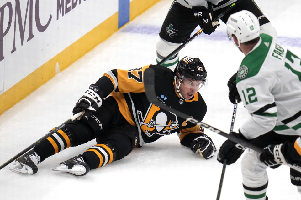 Pittsburgh Penguins' Sidney Crosby (87) falls to the ice after colliding with Dallas Stars' Radek Faksa (12) during the first period of an NHL hockey game in Pittsburgh, Tuesday, Oct. 24, 2023. (AP Photo/Gene J. Puskar)