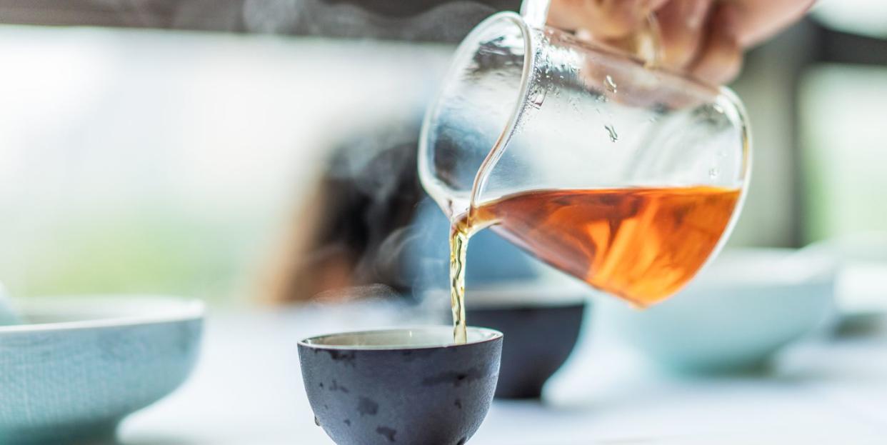 close up of human hands serving chinese tea