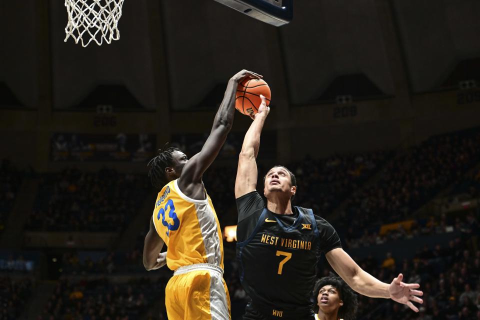 Pittsburgh center Federiko Federiko (33) blocks West Virginia center Jesse Edwards (7) during the first half of an NCAA college basketball game, Wednesday, Dec. 6, 2023, in Morgantown, W.V. (William Wotring/The Dominion-Post via AP)